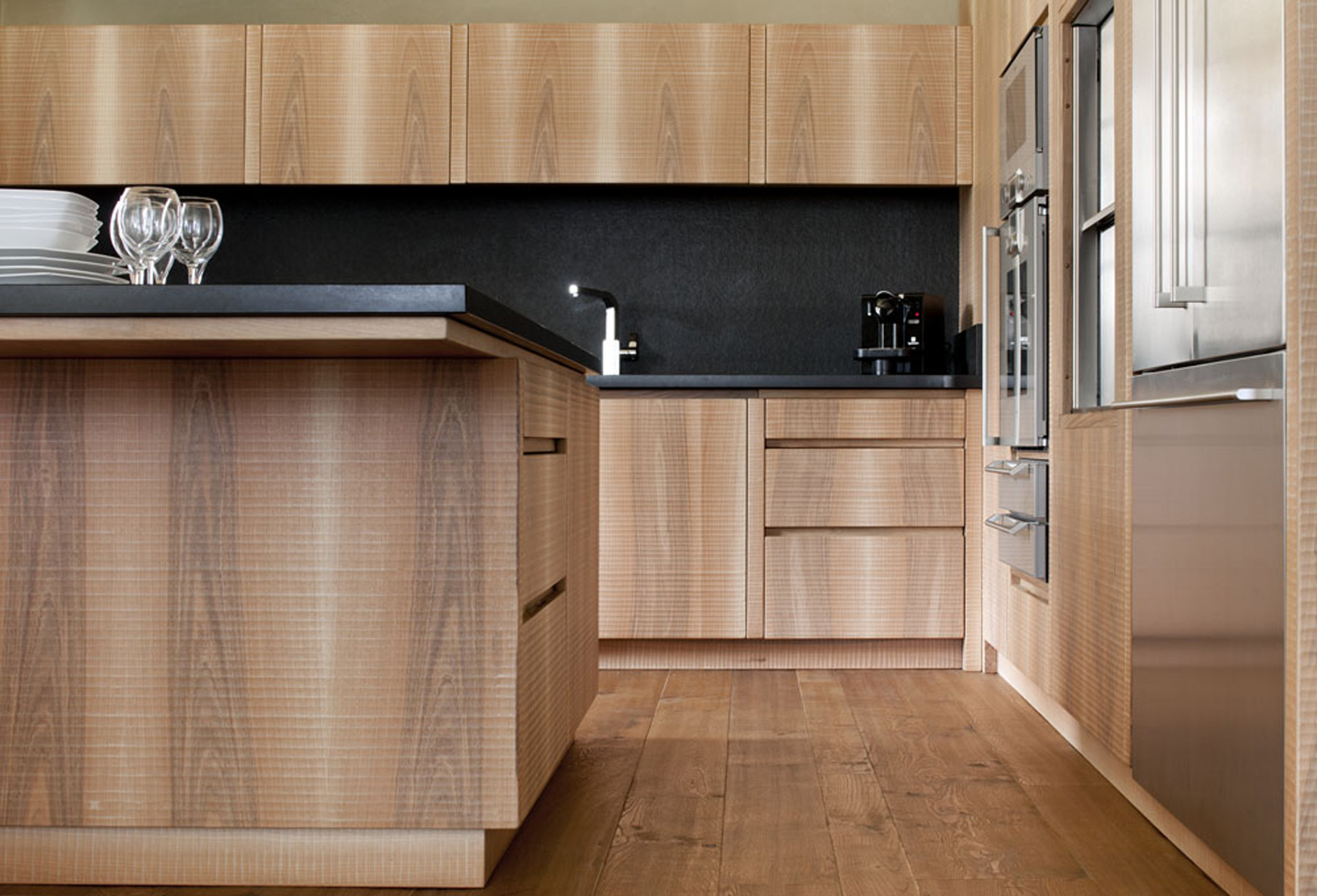 Kitchen in Italian walnut with sheer black granite surface.