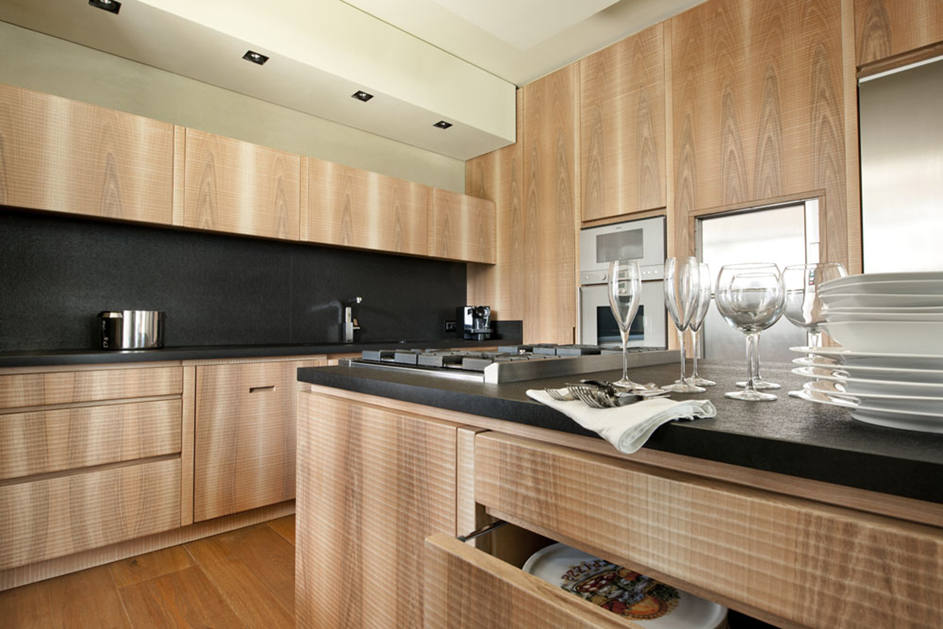 Kitchen in Italian walnut with sheer black granite surface.