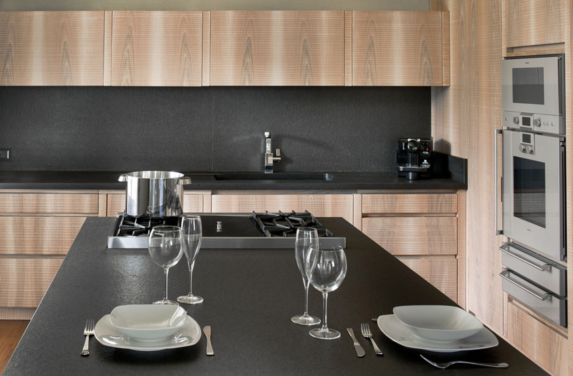 Kitchen in Italian walnut with sheer black granite surface.