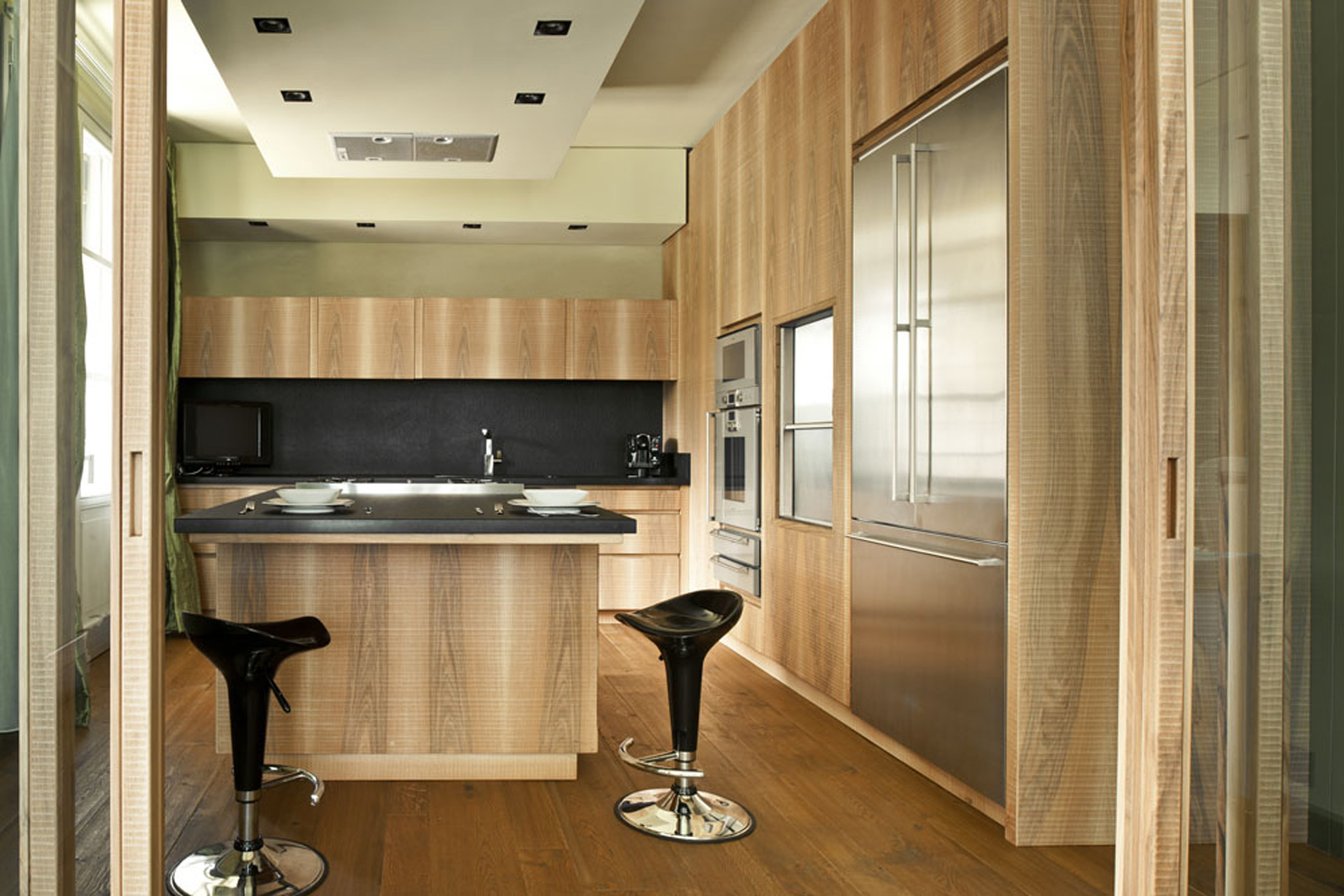 Kitchen in Italian walnut with sheer black granite surface.